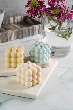 Üç baloncuk mum - soluk mavi yüzey üzerinde bej renkli ve mavi renkli - mermer tahta üzerinde