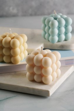 Üç baloncuk mum - soluk mavi yüzey üzerinde bej renkli ve mavi renkli - mermer tahta üzerinde