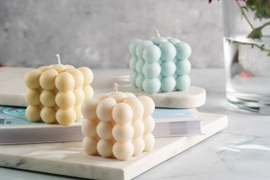 Üç baloncuk mum - soluk mavi yüzey üzerinde bej renkli ve mavi renkli - mermer tahta üzerinde