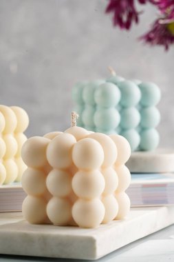 Üç baloncuk mum - soluk mavi yüzey üzerinde bej renkli ve mavi renkli - mermer tahta üzerinde