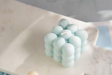 Soluk mavi yüzeydeki mermer tahtada bir mavi baloncuk mumu