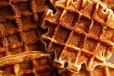 Çerçeveyi bal ve pudra şekerle dolduran taze ev yapımı Belçika waffle 'ları.