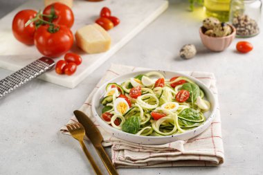 Keto paleo düşük karbonhidratlı makarna: parmesan peynirli kabaklı şehriye, vişneli domates, açık gri yüzeyli bıldırcın yumurtası.