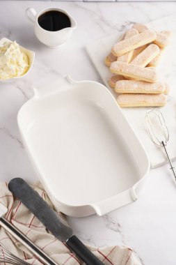 Adım adım İtalyan tatlı tiramisusunu hazırlamak için bayan parmak bisküvileri, mascarpone peyniri, beyaz mermer arka planda espresso