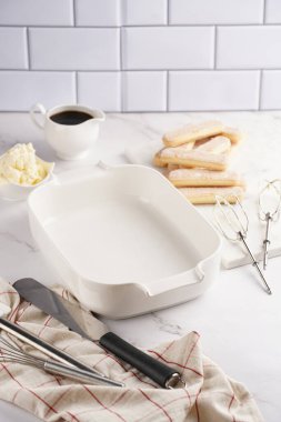 Adım adım İtalyan tatlı tiramisusunu hazırlamak için bayan parmak bisküvileri, mascarpone peyniri, beyaz mermer arka planda espresso