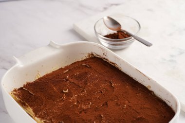 Adım adım İtalyan tatlı tiramisusunu hazırlamak için bayan parmak bisküvileri, mascarpone peyniri, beyaz mermer arka planda espresso