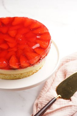 Üç katlı kek, vanilyalı puding, çilekli jöle ve beyaz pasta standında taze çilek.