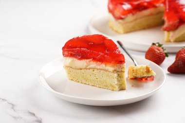 Vanilyalı puding, çilekli jöle ve beyaz mermer arka planda taze çilekli üç katlı bir pasta.