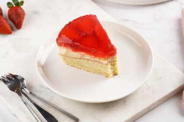 Vanilyalı puding, çilekli jöle ve beyaz mermer arka planda taze çilekli üç katlı bir pasta.