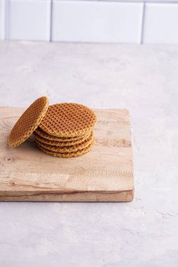 Stroopwafel - geleneksel Hollanda usulü karamelli gözleme - tahta bir tahtanın üzerinde üst üste istiflenmiş, beyaz mutfak