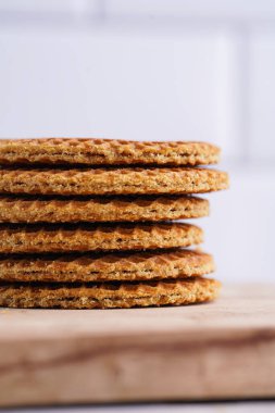 Stroopwafel - geleneksel Hollanda usulü karamelli gözleme - tahtanın üzerinde üst üste istiflenmiş, beyaz mutfak, yakın plan
