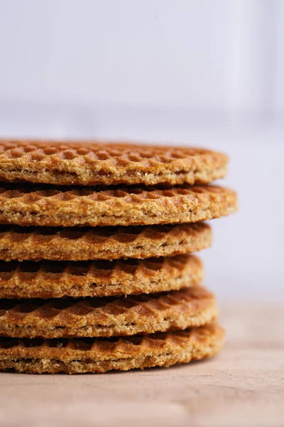Stroopwafel - geleneksel Hollanda usulü karamelli gözleme - tahta bir tahtanın üzerinde üst üste istiflenmiş, beyaz mutfak, kapat