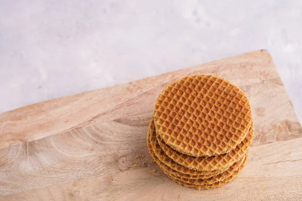 Stroopwafel - geleneksel Hollanda usulü karamelli gözleme - tahta bir tahtanın üzerinde üst üste istiflenmiş, beyaz mutfak