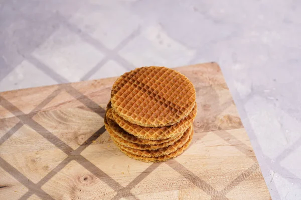 Stroopwafel - geleneksel Hollanda usulü karamelli gözleme - tahta bir tahtanın üzerinde üst üste istiflenmiş, beyaz mutfak