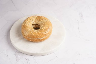 Mermer yuvarlak tahtada ikiye bölünmüş boş bir simit. Sandviç hazırlıyorum.