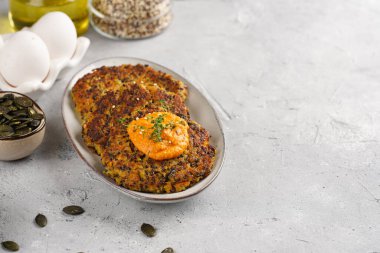 Paprika humusuyla kaplı bir tabakta havuç ve kinoa krepleri, ayçiçeği çekirdekleri. Sağlıklı vejetaryen gıda - bitki temelli diyet konsepti. Boşluğu kopyala