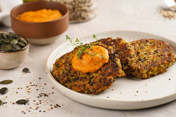 Paprika humusuyla kaplı bir tabakta havuç ve kinoa krepleri, ayçiçeği çekirdekleri. Sağlıklı vejetaryen yiyecekler - bitki temelli diyet kavramı.