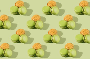 Makarna pastasının sert ışık deseni - iki yeşil ve bir turuncu - açık yeşil yüzeyde fotoğraflandı