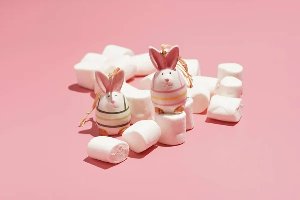 Two Bright Figurines Easter Bunnies Surrounded White Fluffy Marshmallows Pink — стоковое фото