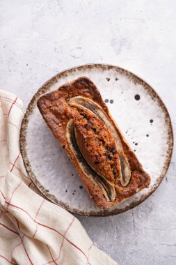 Muzlu çikolatalı ekmek, beyaz bir tabakta ceviz, kahverengi kenarlı, gri tarafsız arka plan, üst manzara.