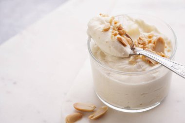 Kremalı yoğurtlu tatlı, krem peynirli ve fıstık ezmeli mermer tepside çay kaşığıyla.