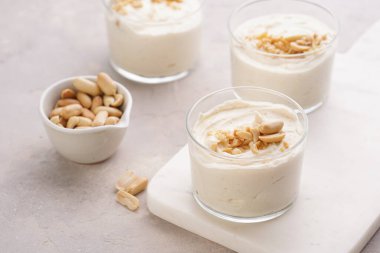 Kremalı yoğurtlu tatlı, krem peynir ve mermer tepside fıstık ezmesi.