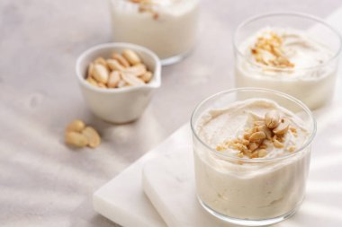 Kremalı yoğurtlu tatlı, krem peynir ve mermer tepside fıstık ezmesi.