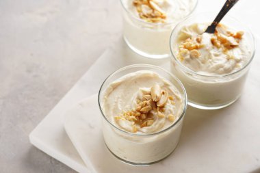 Kremalı yoğurtlu tatlı, krem peynirli ve fıstık ezmeli mermer tepside çay kaşığıyla.