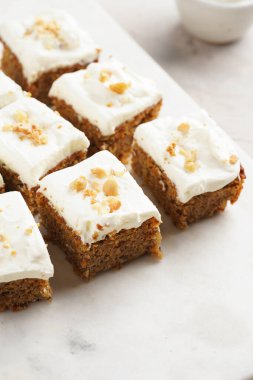 Ev yapımı havuçlu cevizli kek, topraklanmış badem, fındıklı ve mermer tahtada beyaz krem peynirli.