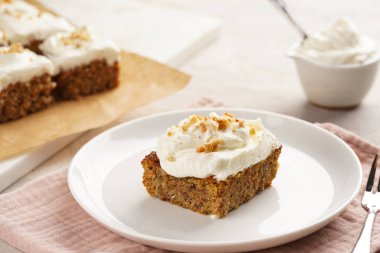 Ev yapımı havuçlu cevizli kek. Topraklanmış badem, fındıklı ve beyaz krem peynirli. Pembe peçeteli.