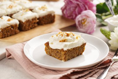 Ev yapımı havuçlu cevizli kek. Topraklanmış badem, fındıklı ve beyaz krem peynirli. Pembe peçeteli.