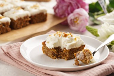 Ev yapımı havuçlu cevizli kek. Topraklanmış badem, fındıklı ve beyaz krem peynirli. Pembe peçeteli.