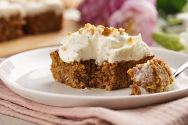 Ev yapımı havuçlu cevizli kek. Topraklanmış badem, fındıklı ve beyaz krem peynirli. Pembe peçeteli.