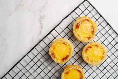 Geleneksel Portekiz vanilyalı puding puf puf pastası siyah fırın rafında mermer zemin - üst görünüm