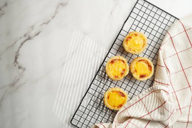 Geleneksel Portekiz vanilyalı puding puf puf pastası siyah fırın rafında mermer zemin - üst görünüm, kopyalama alanı