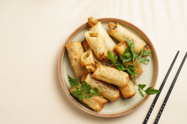 Geleneksel Güneydoğu Asya başlangıç tabağı bahar veya yaz börekleri - soya soslu bol kızarmış Dim Sum köftesi, siyah pirzola çubuklarıyla gri tabakta taze kişniş, üst manzara