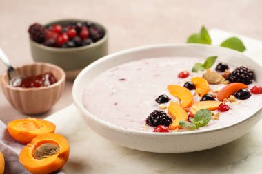 Geleneksel kahvaltı irmik lapası - kayısı dilimli mor kremalı puding, donmuş böğürtlen, taze nane, mermer tahtada reçel