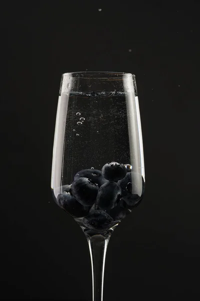 Champagne Glass Black Background Contour Light Sparkling Liquid Blueberries — стоковое фото