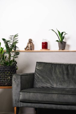 İç dekorasyon: Cam kavanozda boş kırmızı sütun mumu. Kanepenin önündeki ahşap masada etiketsiz.