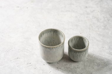 empty grey ceramic espresso and coffee mugs on a grey background