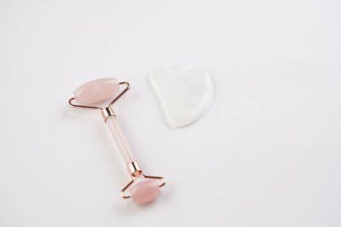 Tools for spa and face wellness cleansing - rose quartz face roller, gua sha massager, top view