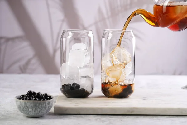 Female Hand Pouring Black Tea Transparent Glass Ice Cubes Cooked — Stock Fotó