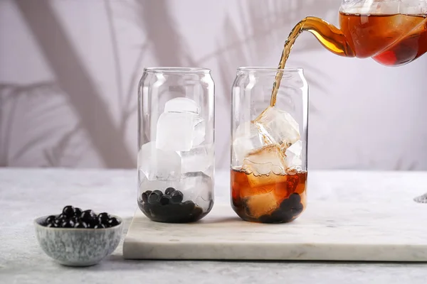 Female Hand Pouring Black Tea Transparent Glass Ice Cubes Cooked — Stock fotografie