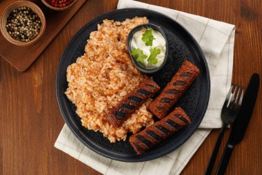 Geleneksel Güney Avrupa 'nın derisiz sosisleri öğütülmüş et ve siyah tahta tabakta baharatlardan yapılmış, soya proteininden yapılmış, pirinç ve ekşi krema ile vejetaryen ikamesi, üst görünüm