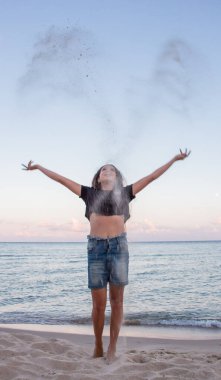 Yazın kumsala kum döken kız.