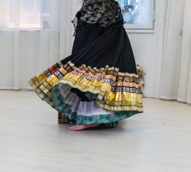 Dans eden bir kadının üzerinde altın kenarlı siyah Hintli etek, belden aşağısı manzaralı.
