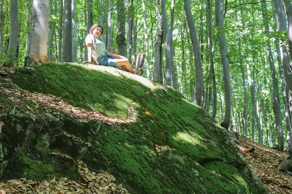 Una Ragazza Adolescente Siede Una Grande Pietra Muschiata Nella Foresta — Foto Stock