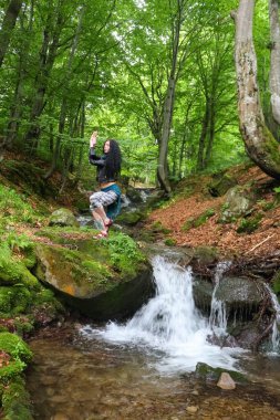 Esmer bir kadın yaz ormanında yoga pozu veriyor Ukraynalı Karpatlar, açık hava yaşamı.