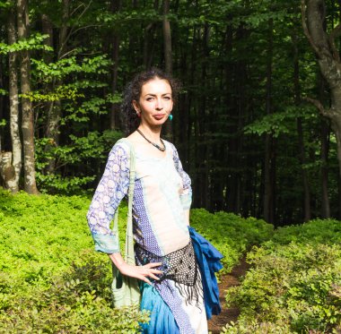 Genç esmer kadın Karpatya ormanlarında bir yolda, yaz, Ukrayna, boho tarzı kıyafetler