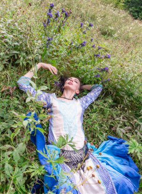 Bir kadın çiçek çayırında dinleniyor, Karpat dağlarında, yaz mevsiminde.